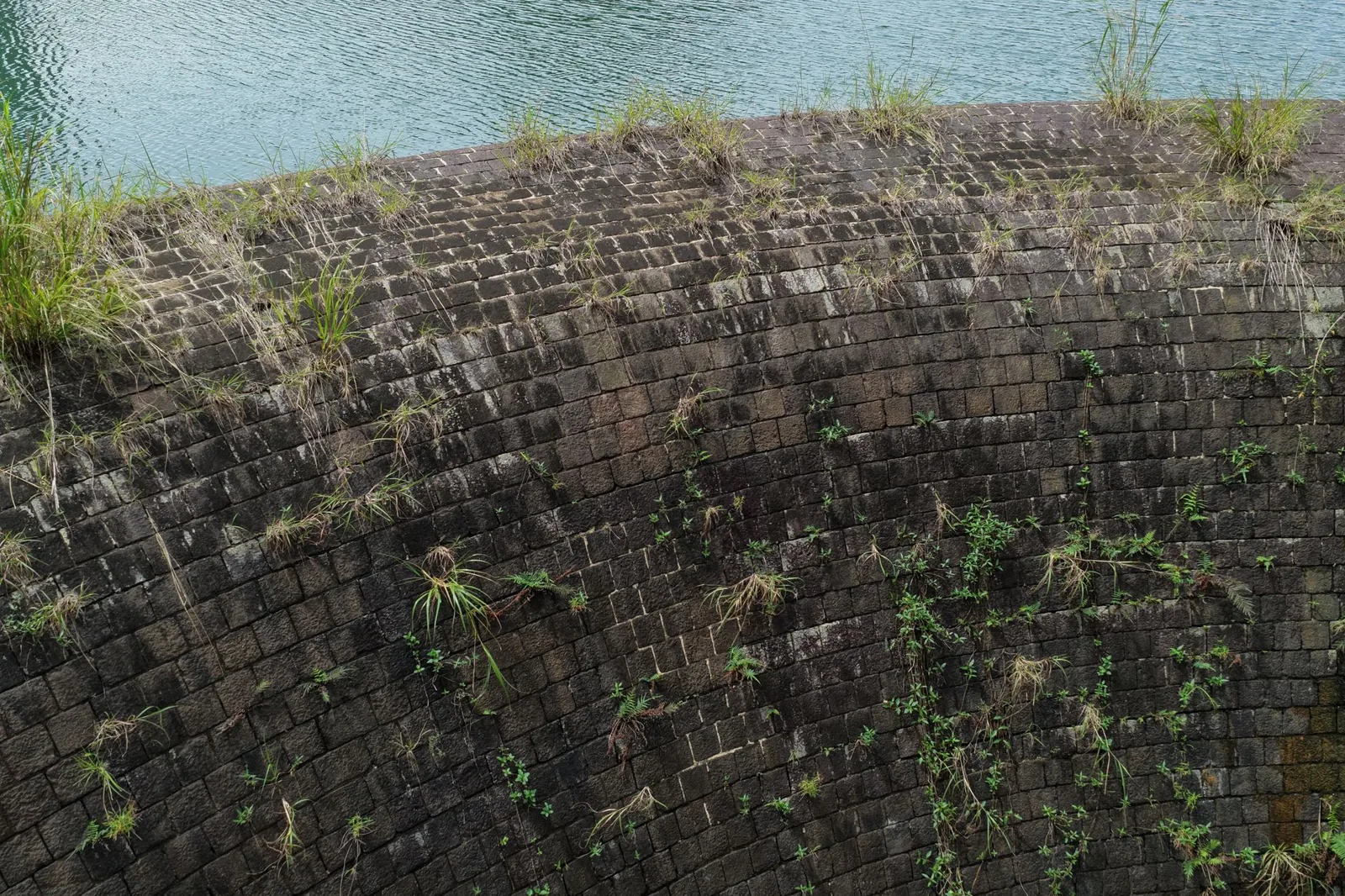 Retaining wall repair cost for a leaning stone wall being rebuilt by a mason