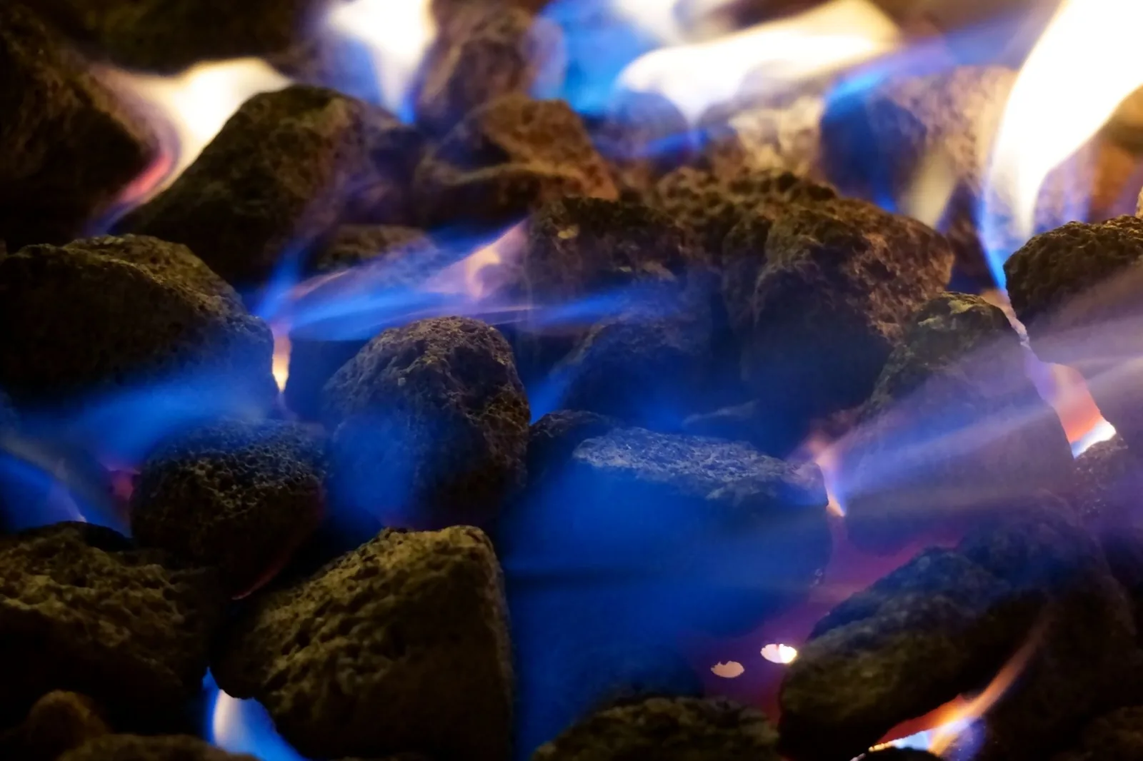 gas vs charcoal fire pit side by side in a backyard