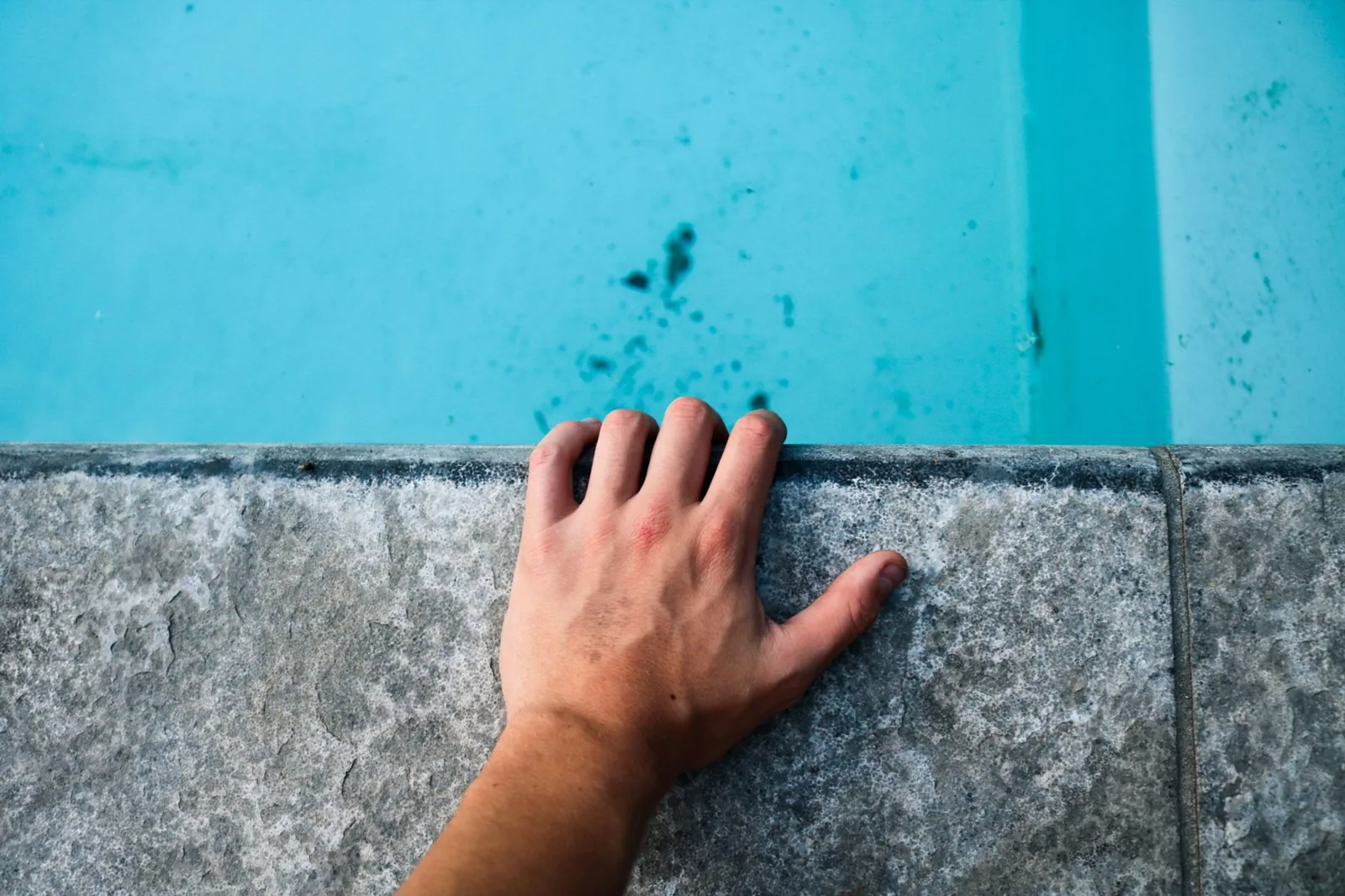 Fiberglass pool cost vs concrete comparison showing a modern blue fiberglass pool shell in a backyard
