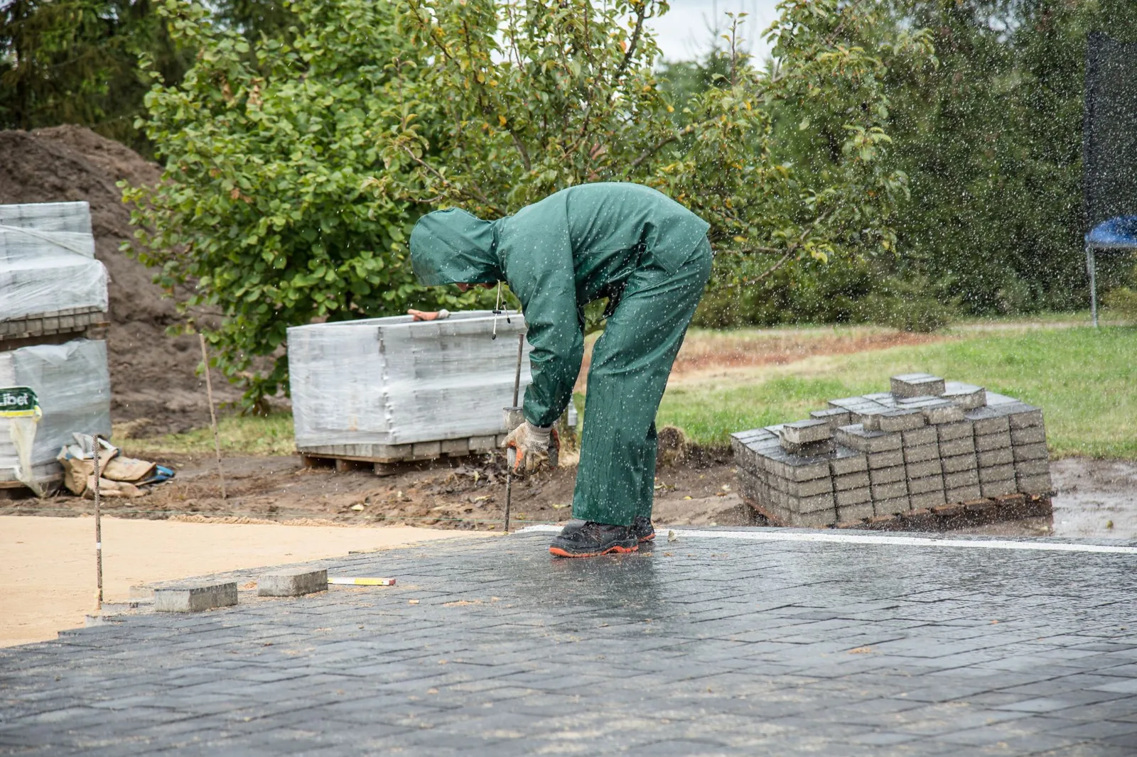 how to install a french drain in yard — a gravel-filled trench lined with landscape fabric in a backyard