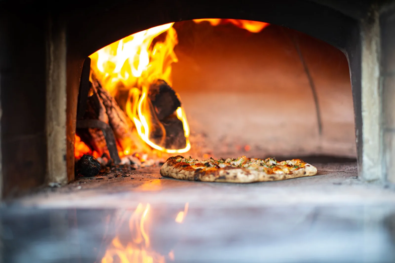 outdoor pizza oven built into a stone island