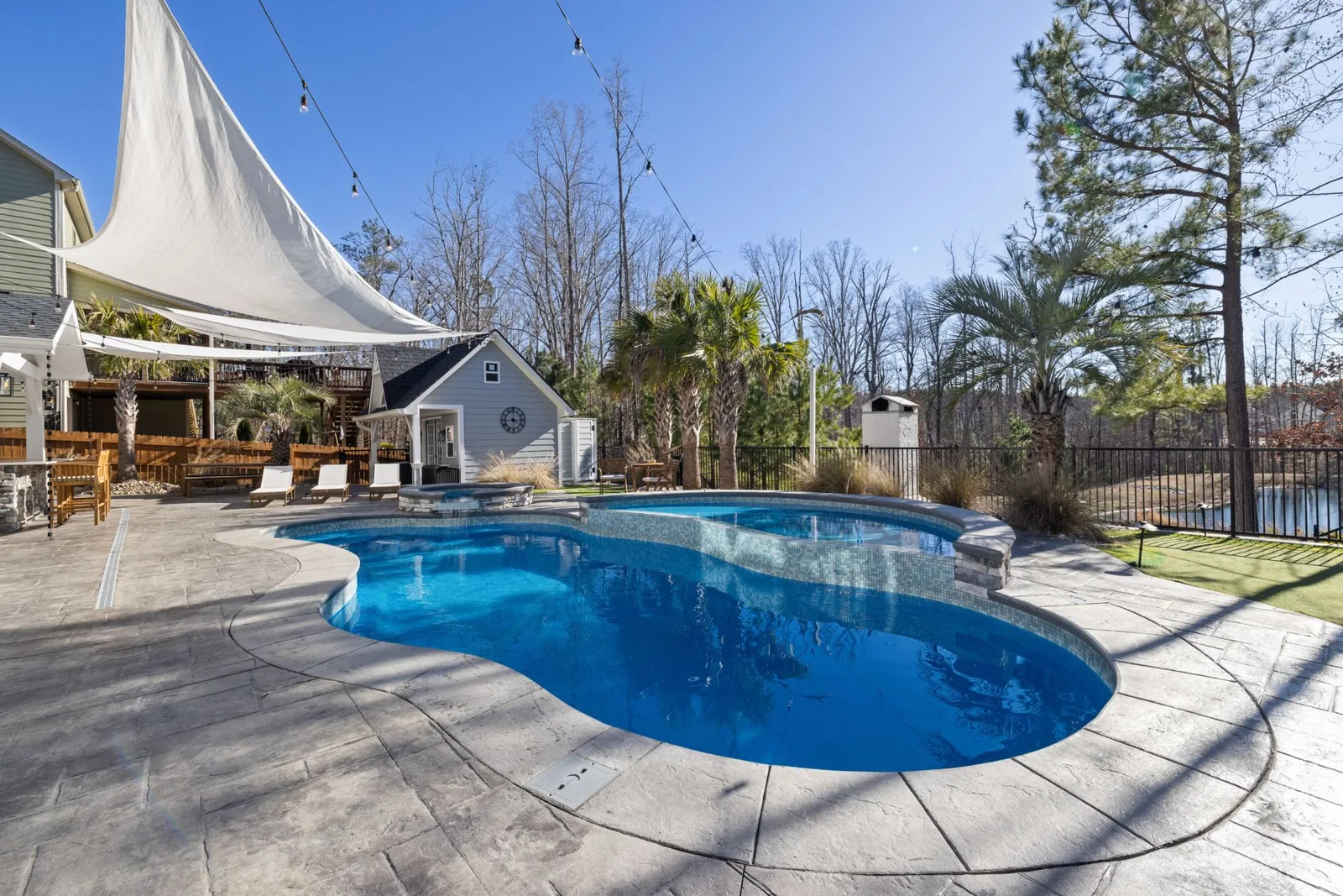 Backyard fiberglass swimming pool with clean water and landscaping