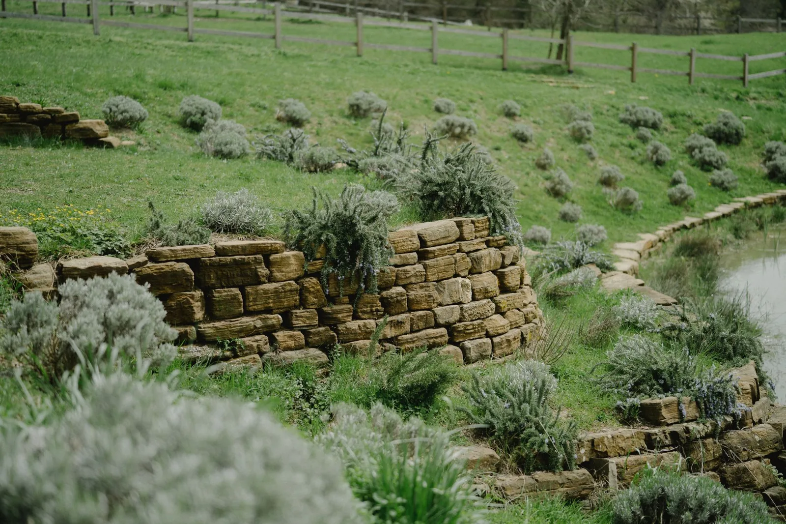 Stepping a retaining wall down a grassy slope